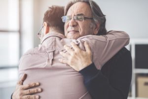 two people hug after learning the level of senior care needed