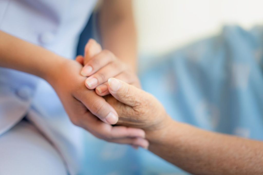 two pairs of hands are held in comfort one of the benefits of long-term skilled nursing care