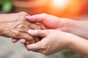 a person Caring for someone with dementia holds their hands