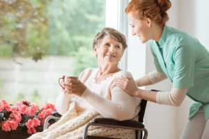 Caregiver and resident smiling at one another in professional senior memory care
