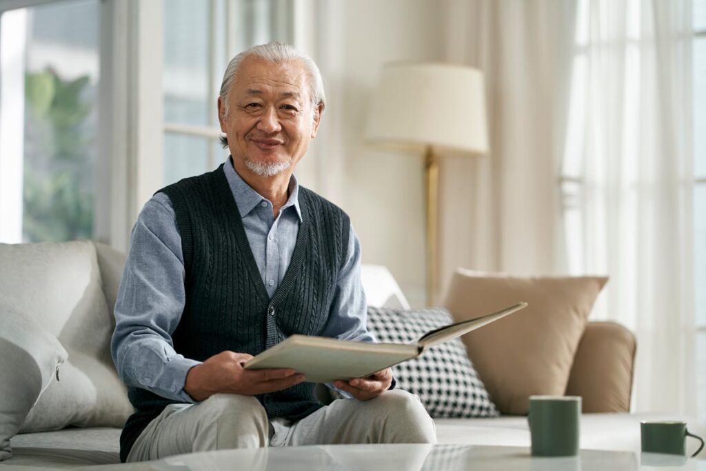 Happy man reading a book while illustrating the importance of senior independent living