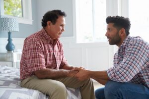 Senior father and adult son discussing signs of Alzheimer's