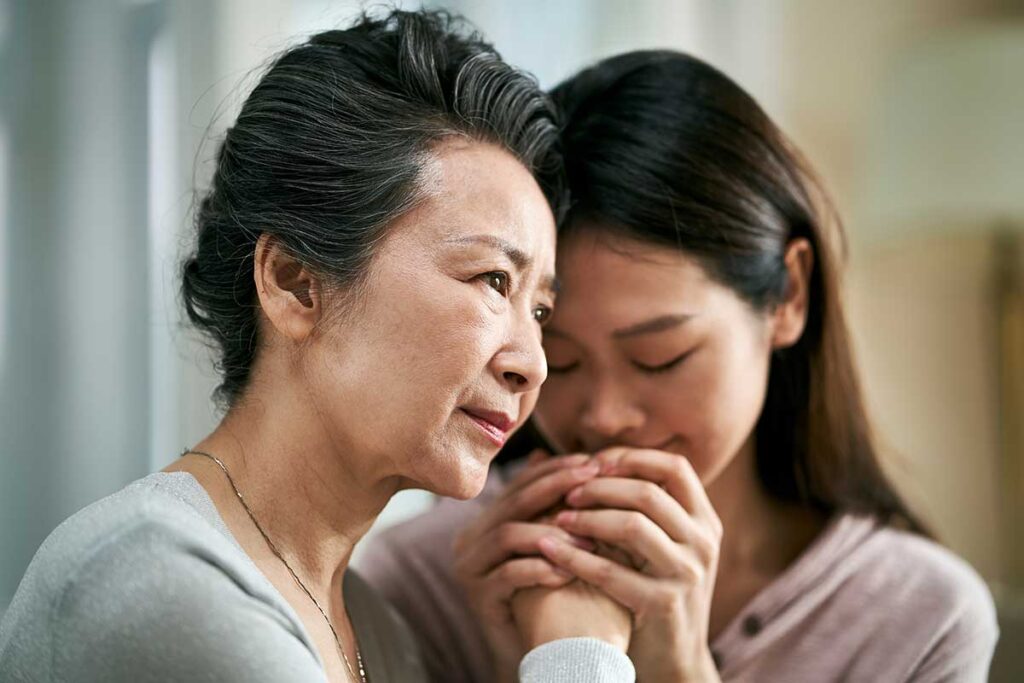 Daughter comforting parent with dementia diagnosis