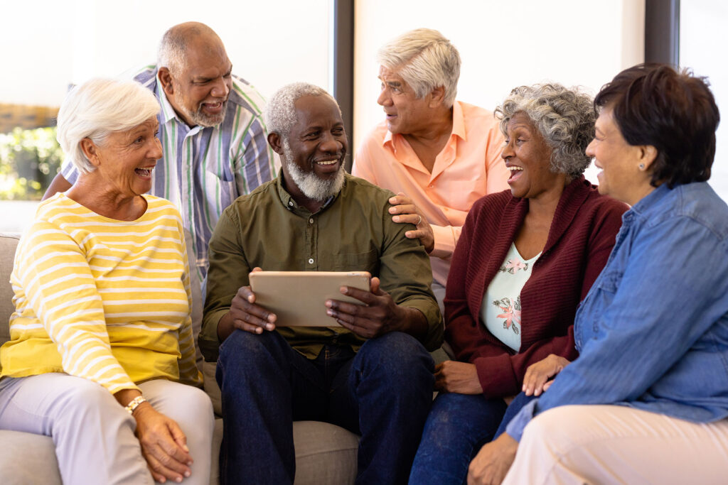 Seniors gathered together with tablet searching for examples of independent living