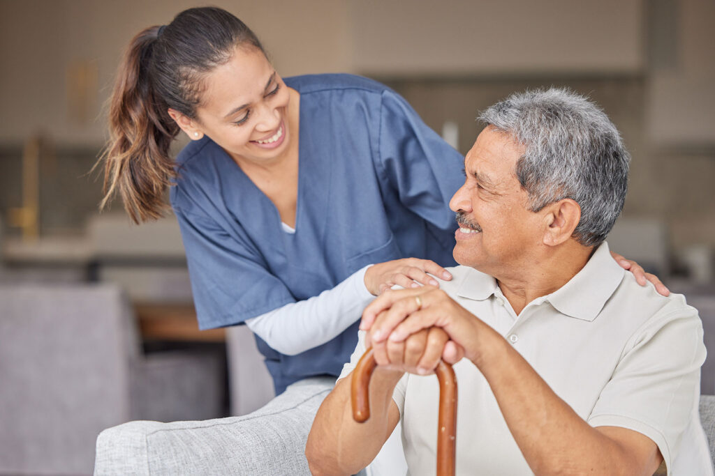 Happy senior man and smiling caregiver discussing signs you need assisted living