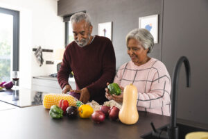 senior couple making healthy dinner after learning healthy aging tips