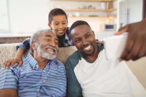 family smiling while posing for selfie and fostering family relationships in assisted living