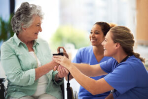 caretakers explaining how assisted living select elevates senior care to a smiling senior