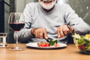 person eating wholesome meal after overcoming common nutritional challenges in senior living