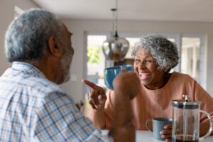 two seniors talking and laughing while enjoying daily life in a memory care center