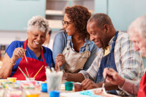 group of senior adults painting after learning the importance of social activities in senior living centers