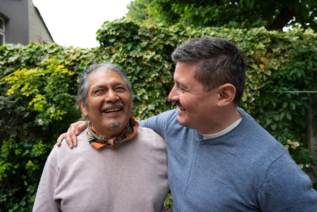 father and son smiling outdoors after discovering what families are looking for in senior living centers